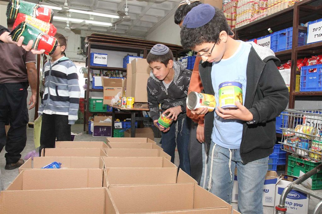 מתנדבים אורזים מצרכי מזון לנזקקים במרכז החדש של חסדי נעמי בירושלים